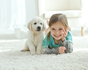 Kind mit Hund auf einem kuschligen Kinderteppich